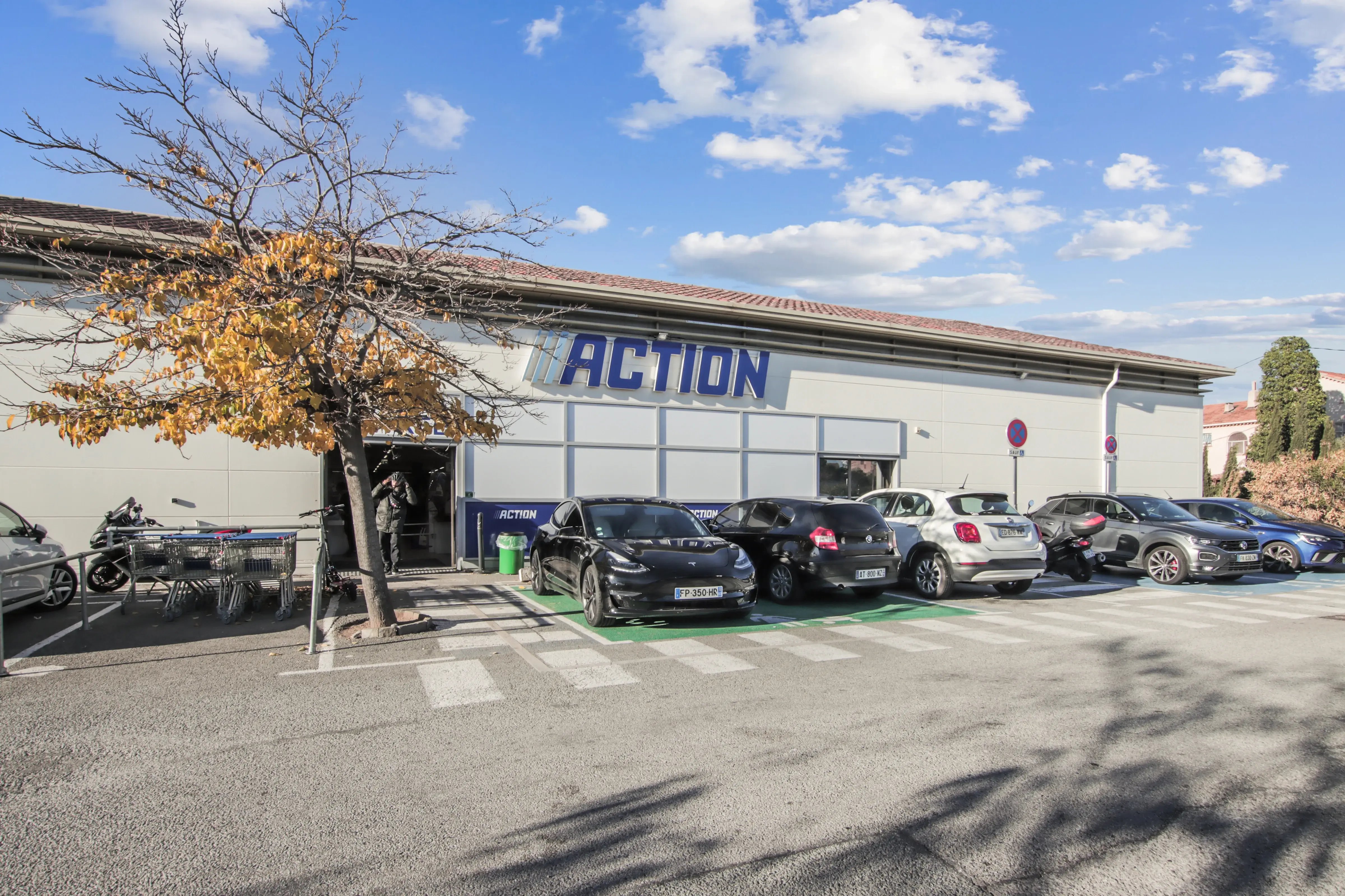 Magasin Action avec parking et ciel dégagé.